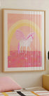 un poster incorniciato di un unicorno con una combinazione di colori rosa e bianco, su uno sfondo rosa e giallo con un arco arcobaleno.