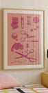 un poster incorniciato di strumenti per cucire e per l'artigianato, tra cui forbici, spille, aghi e altri oggetti legati al cucito, appeso a una parete sopra un letto.