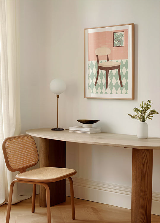 un angolo accogliente di una stanza con una scrivania in legno, una sedia intrecciata, una lampada e un'opera d'arte incorniciata raffigurante una sedia su un pavimento a motivi geometrici.