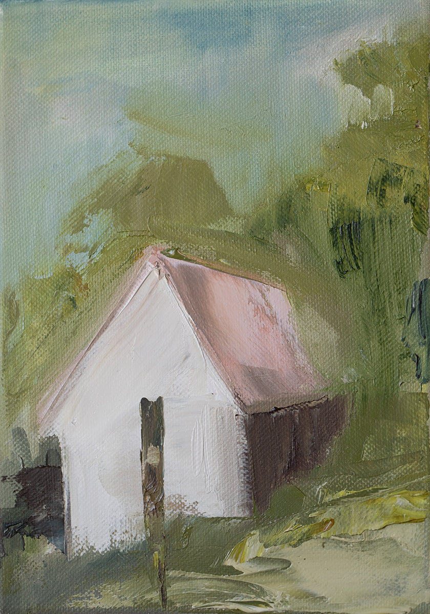 una casa bianca con un tetto rosa, incastonata in un paesaggio verde lussureggiante con alberi e fogliame.
